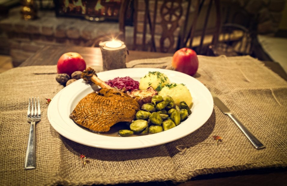 Cuisse d'oie rôtie servie avec chou rouge, knödel et choux de Bruxelles